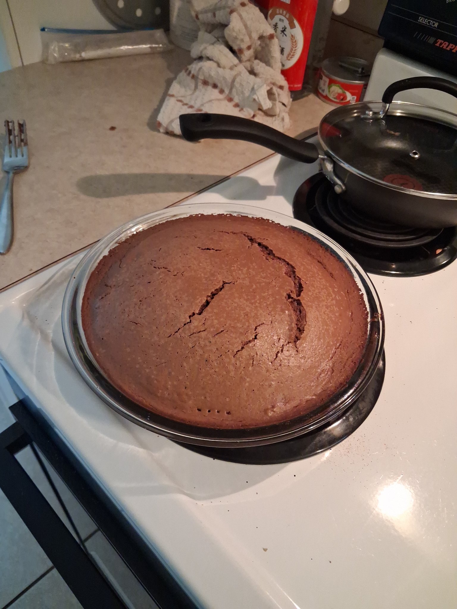 Freshly baked chocolate cake in a round glass baking dish