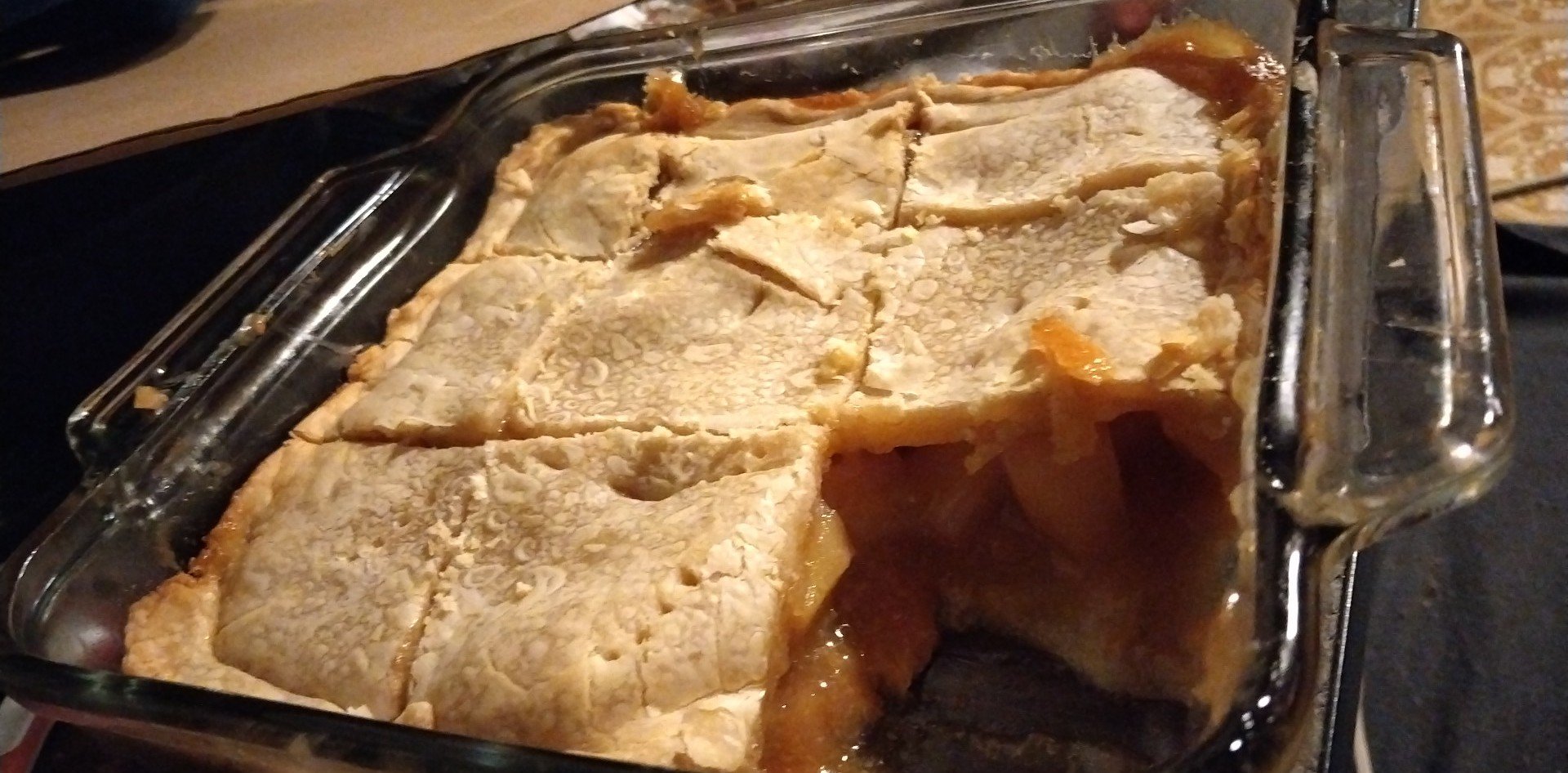 Homemade peach cobbler baked in a rectangular glass dish