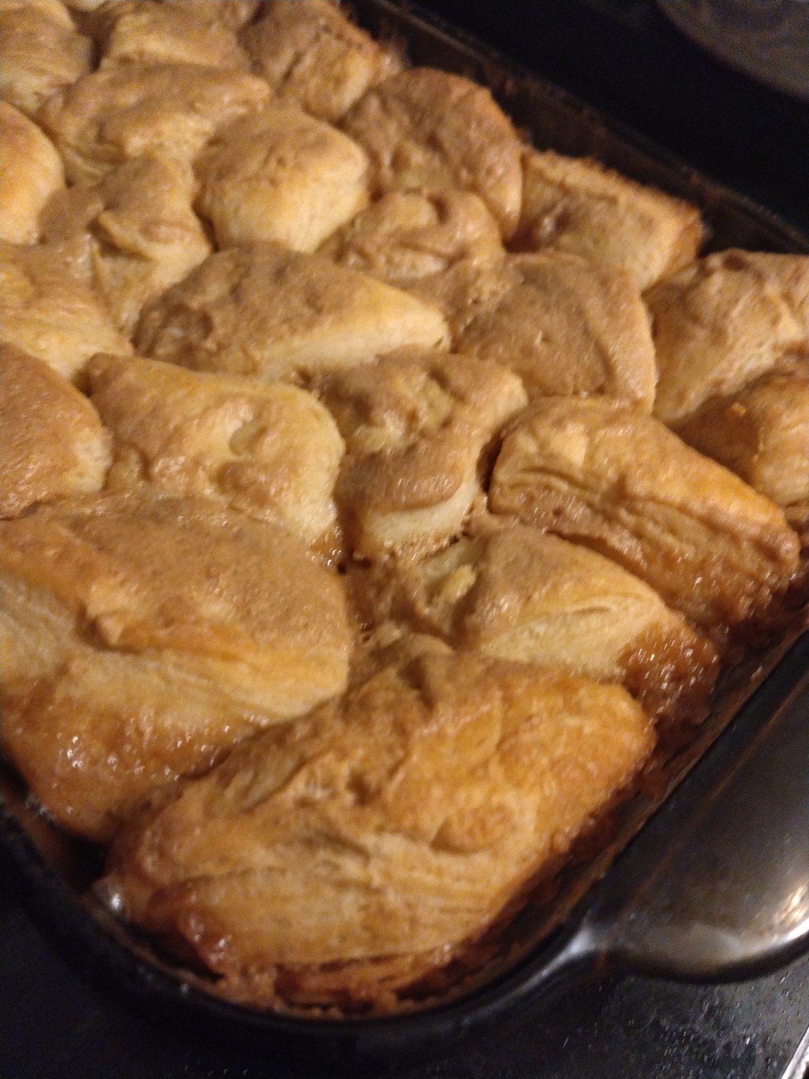 Golden baked pull-apart rolls in a glass baking dish