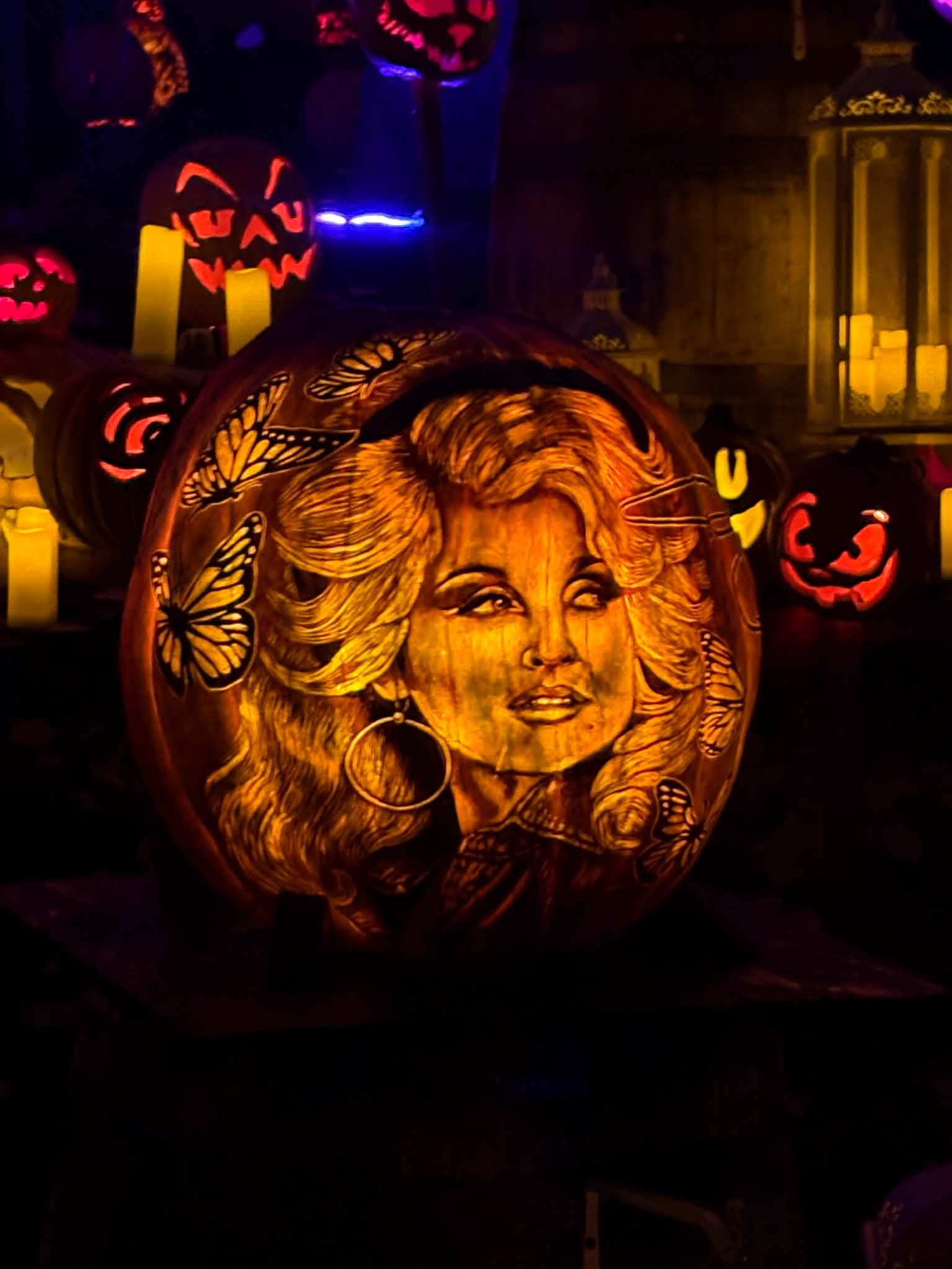 Dolly Parton pumpkin carving surrounded by butterflies