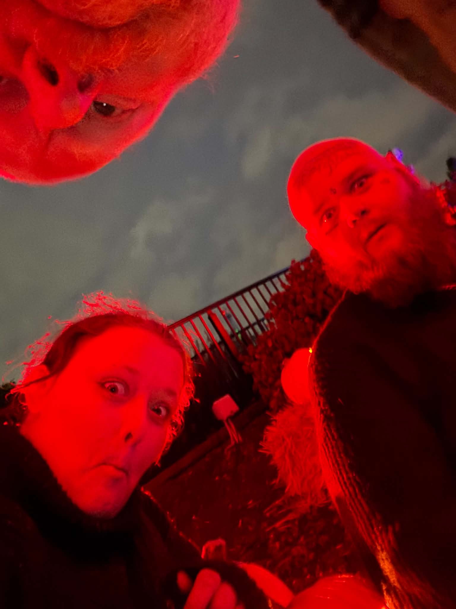 Group selfie taken under red lights at Pumpkin Fest