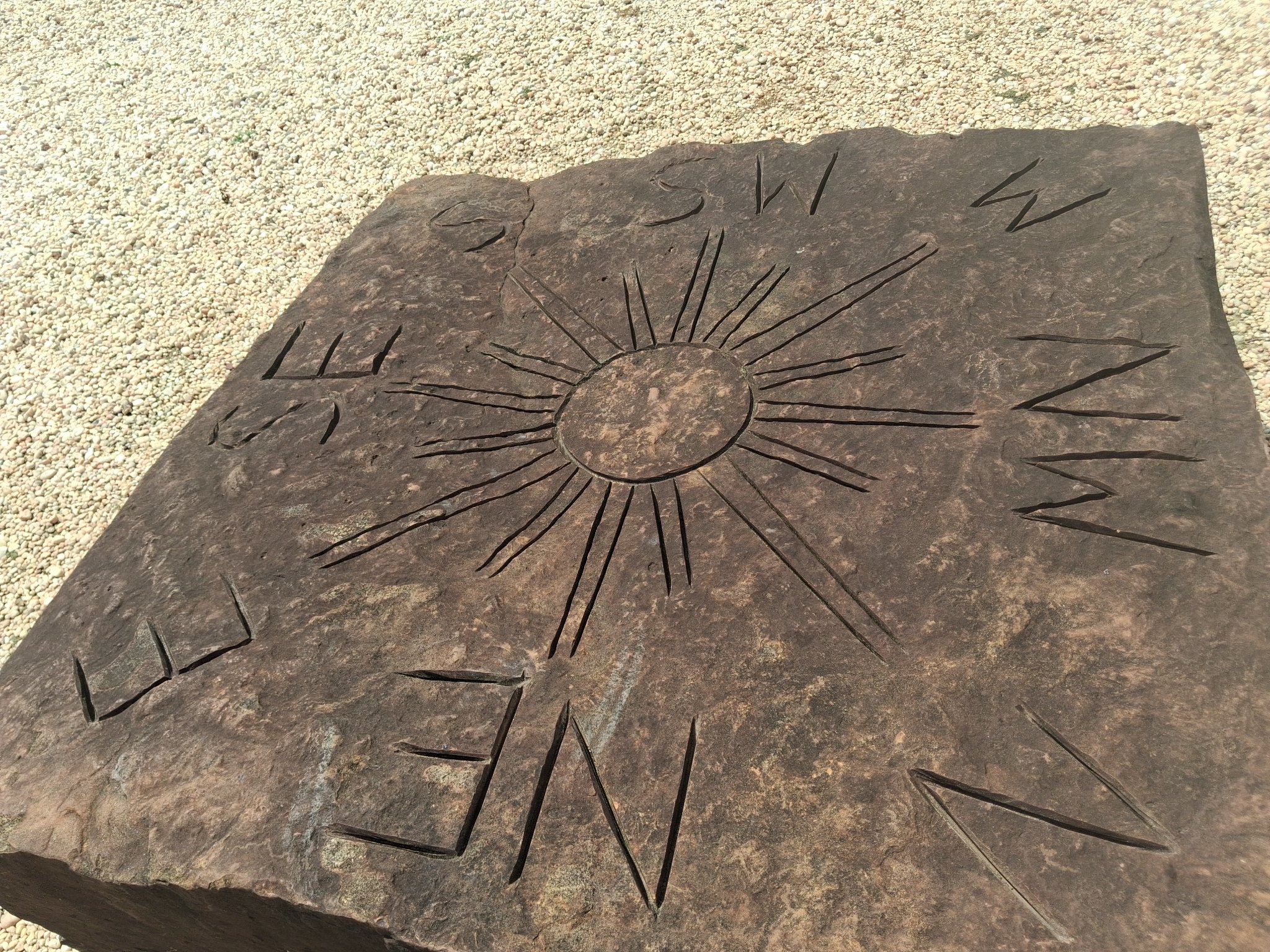 Carved stone sundial marked with compass directions at Stonehenge Kentucky
