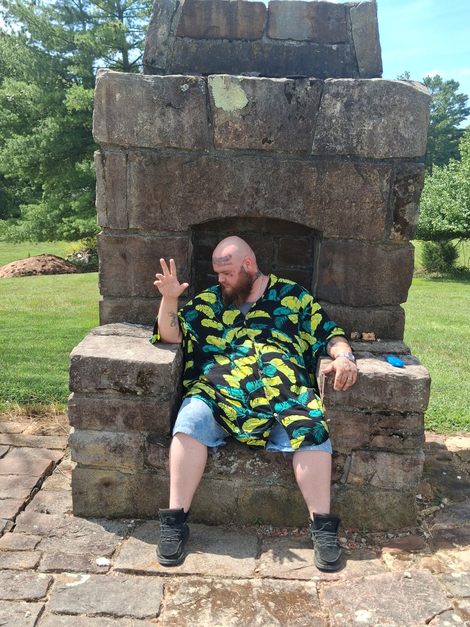Man sitting in a large rustic stone chair at Stonehenge Kentucky